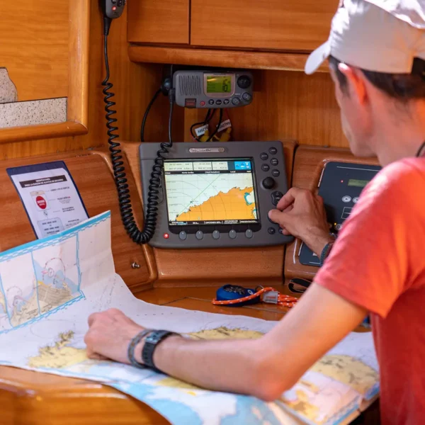 Alumno estudiando carta náutica a bordo durante el curso PER a bordo